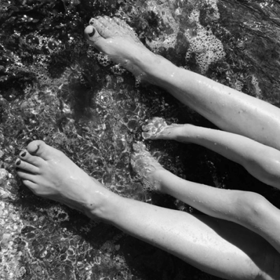 Seth and mum Angie with feet in the sea at the beach